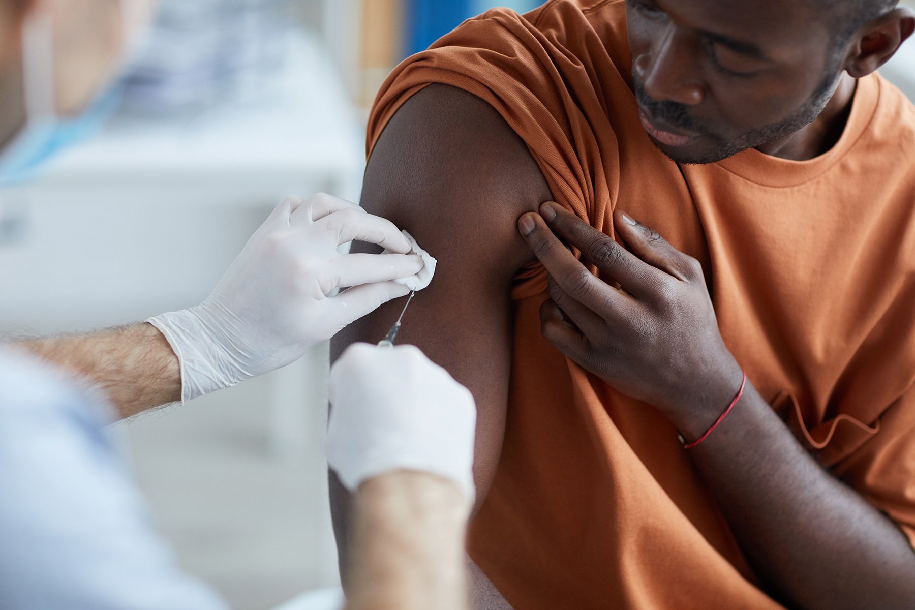African American male receiving covid vaccine from medical worker