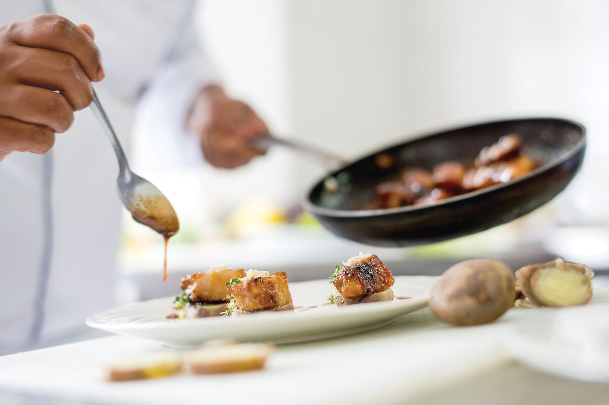 Close up of a chef preparing a dish at Brasserie by Chef Aless.