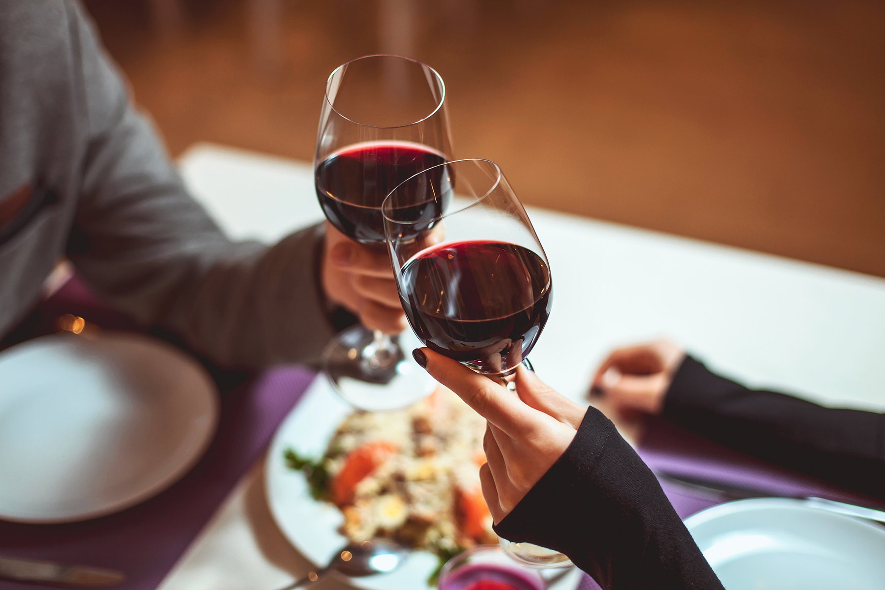 Couple toasting with wine glasses over valentines dinner in restaurant