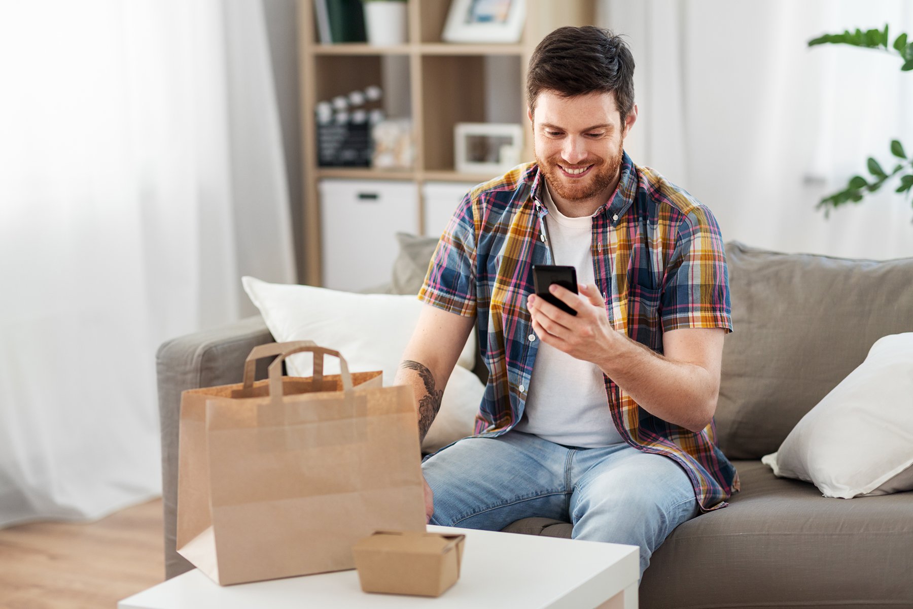 Guy looking at food ordering app after food arrives