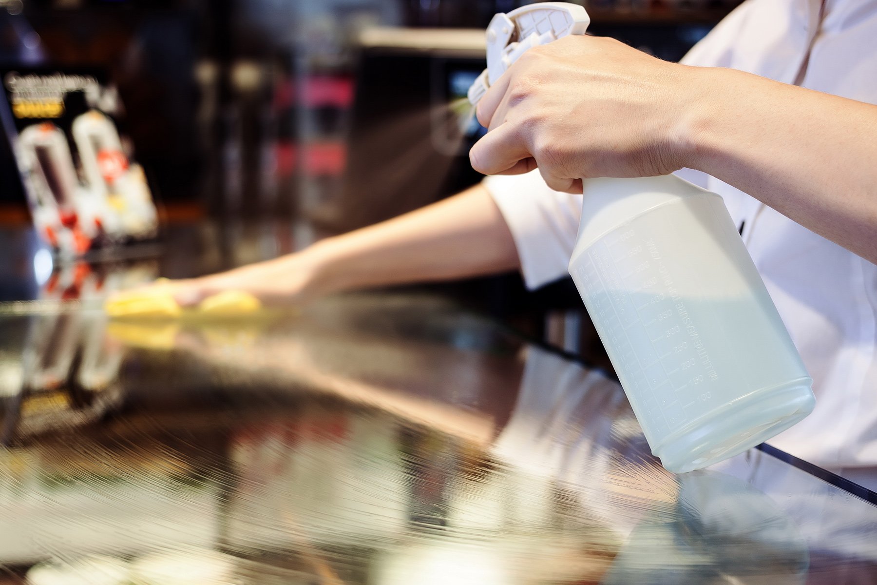 Restaurant worker spraying tables