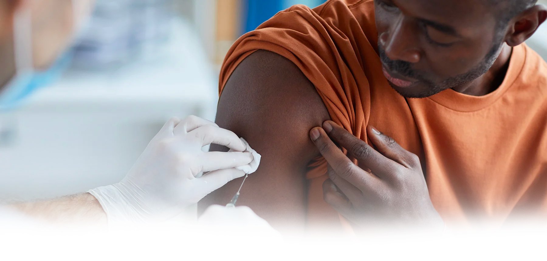 African american male receiving covid vaccine from doctor