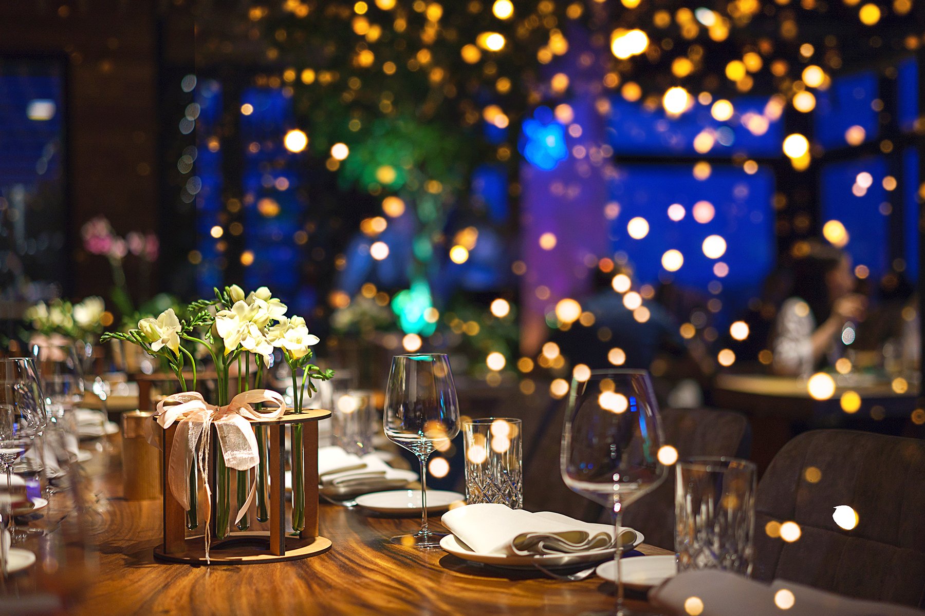 Holiday Dinner Table with Glassware and Warm Bokeh Lights in Background.jpg