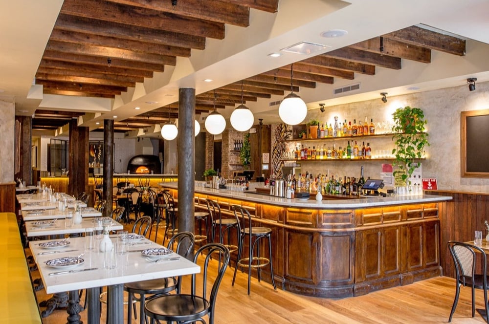 Tables and bar at Gia Bowery restaurant