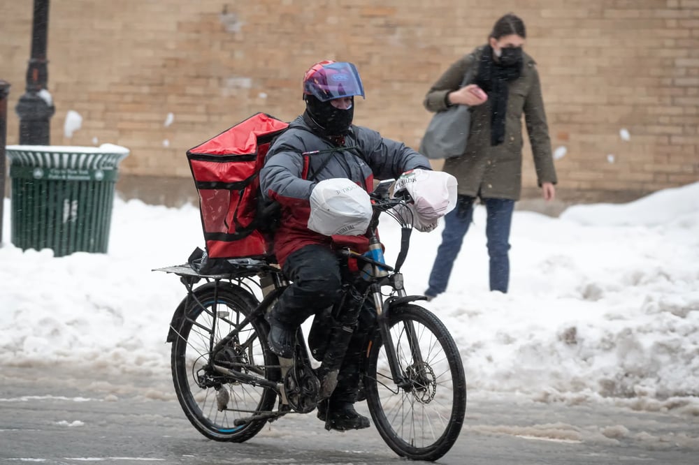 Food delivery man on a bike during winter