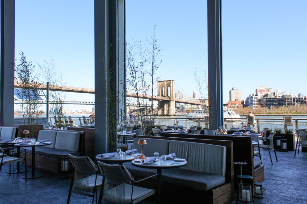 interior shot of the Fulton with large windows showing a bridge in the background