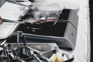 two pans simmering on an induction stove