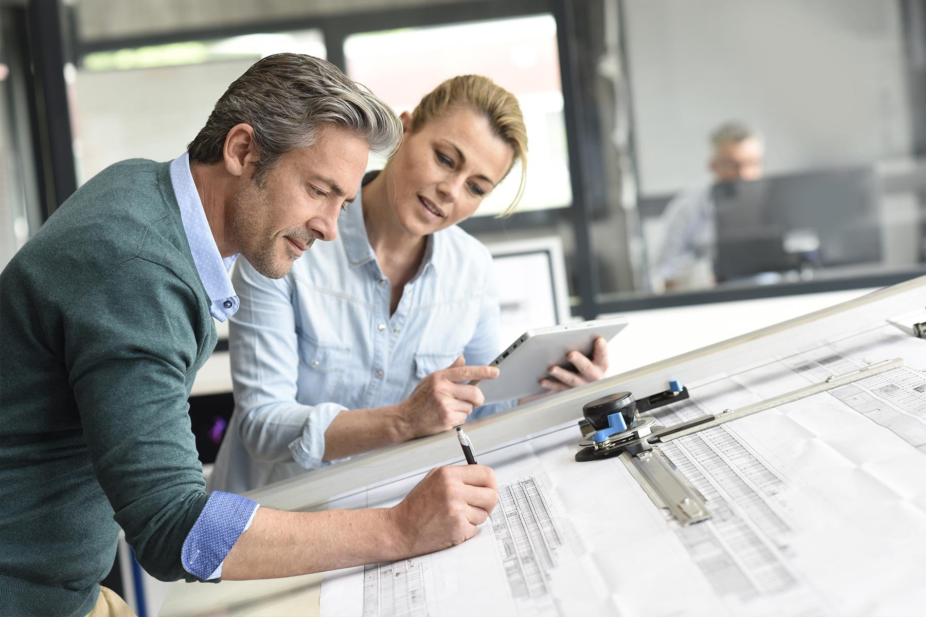 Project Managers looking at blueprints for project