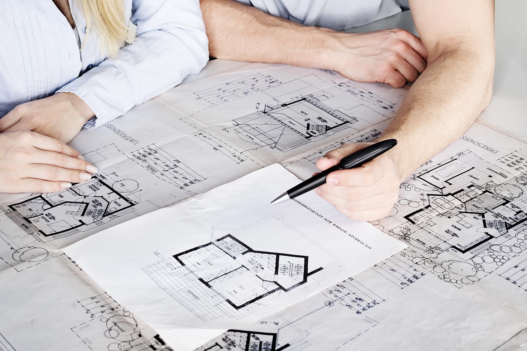 Man and woman looking at blueprints for restaurant kitchen