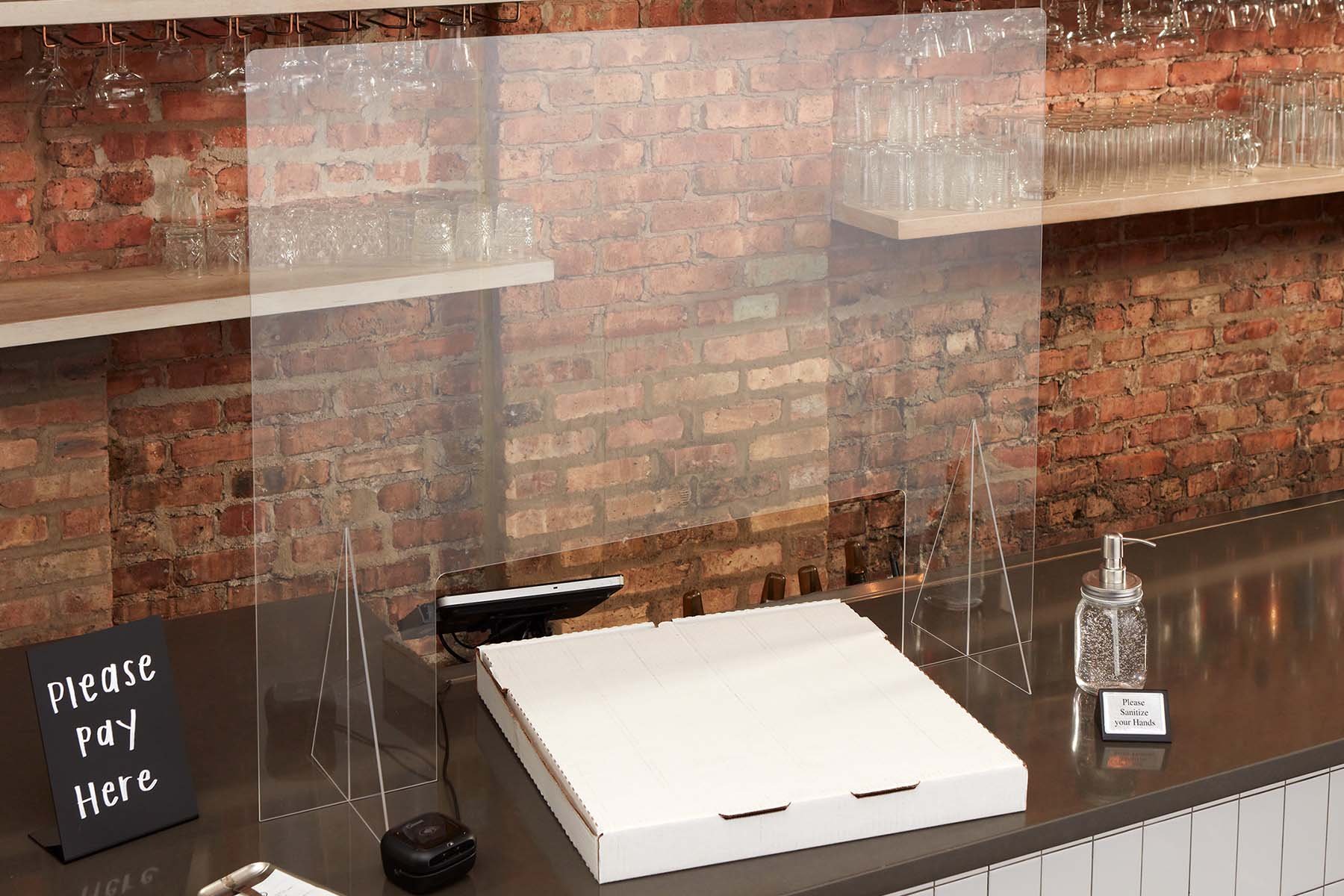counter at a restaurant with a glass partition for covid safety