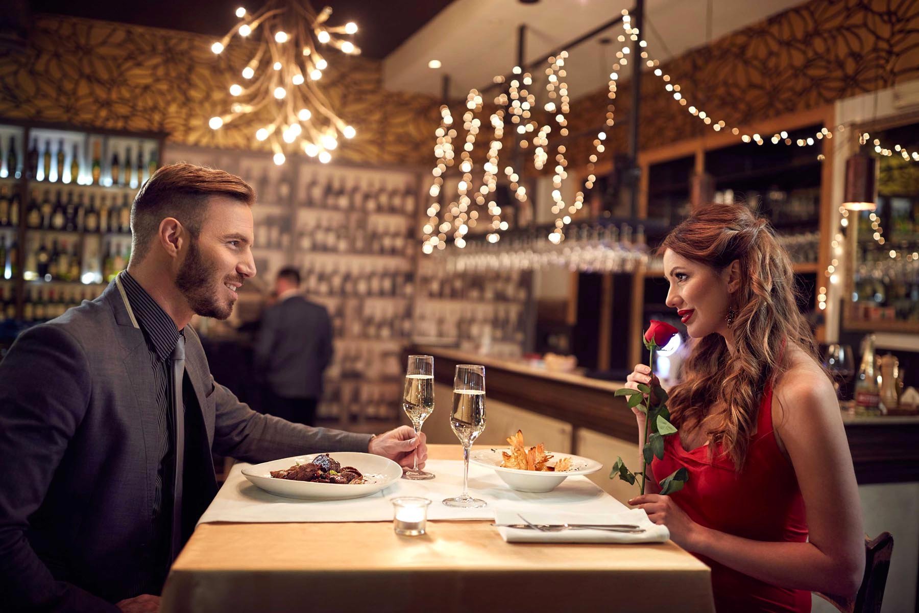 man and a woman at a restaurant having a romantic Valentine's dinner