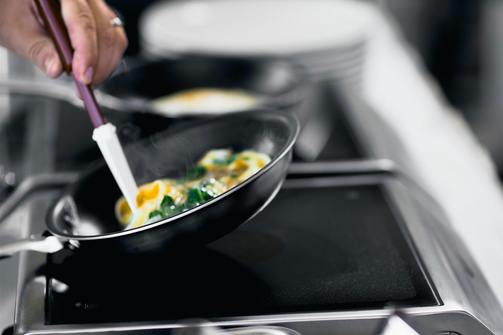 A closeup of a person frying an omelet.