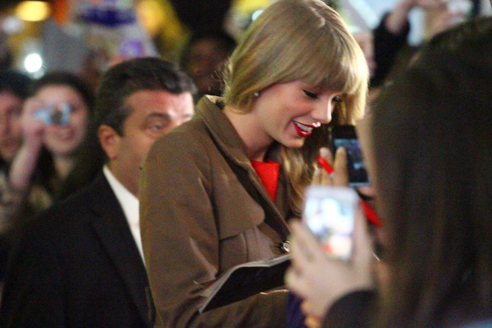 Taylor Swift signing autographs for fans.