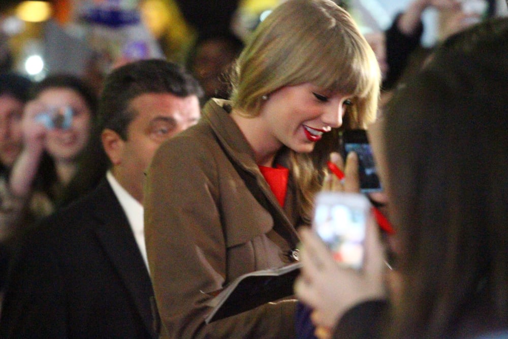 Taylor Swift signing autographs for fans.