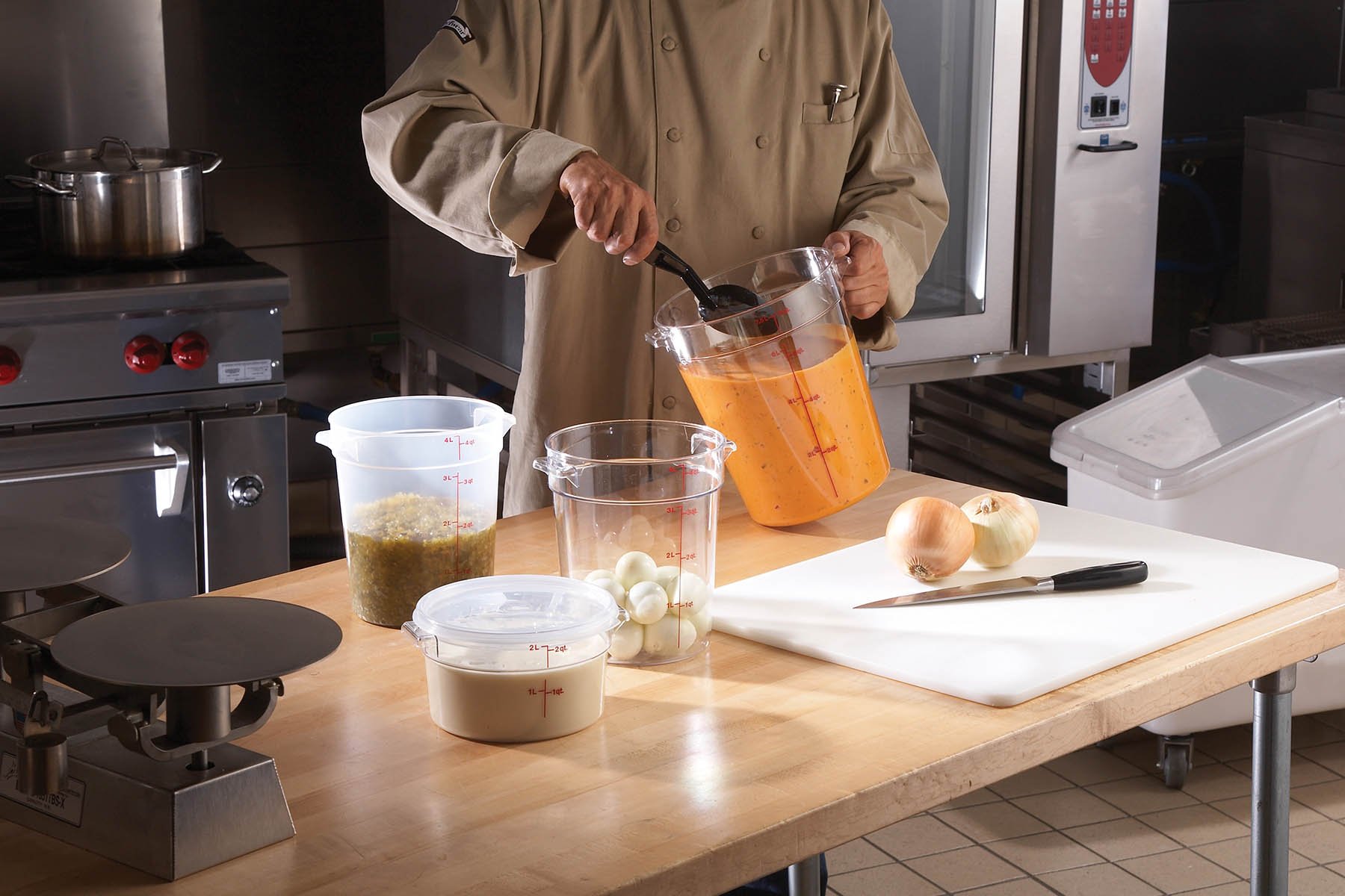 chef mixing ingredients in a cambro container